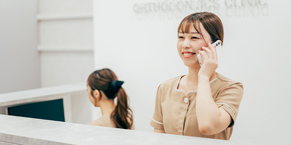 電話予約を受けているシーク歯科・矯正歯科の受付の女性